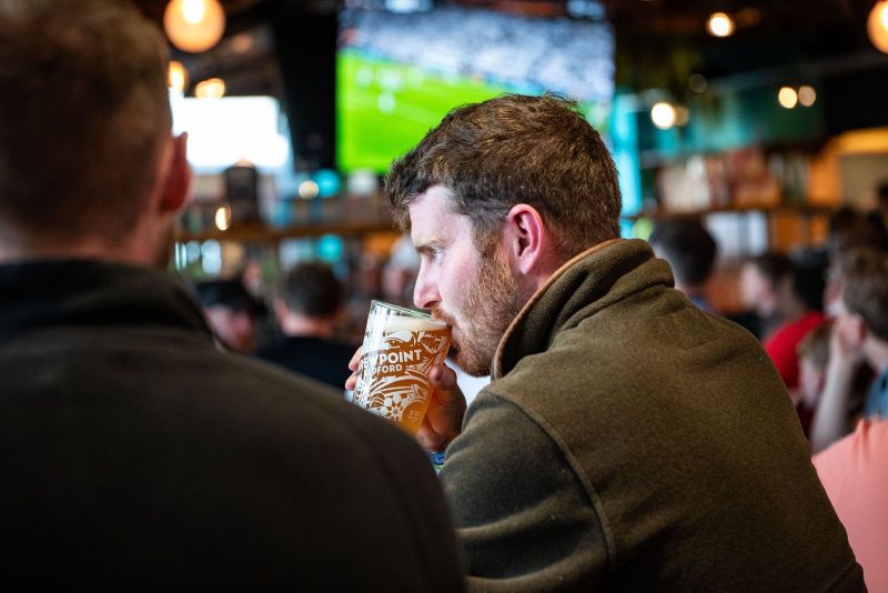 Drinking a pint whilst watching live sport with friends